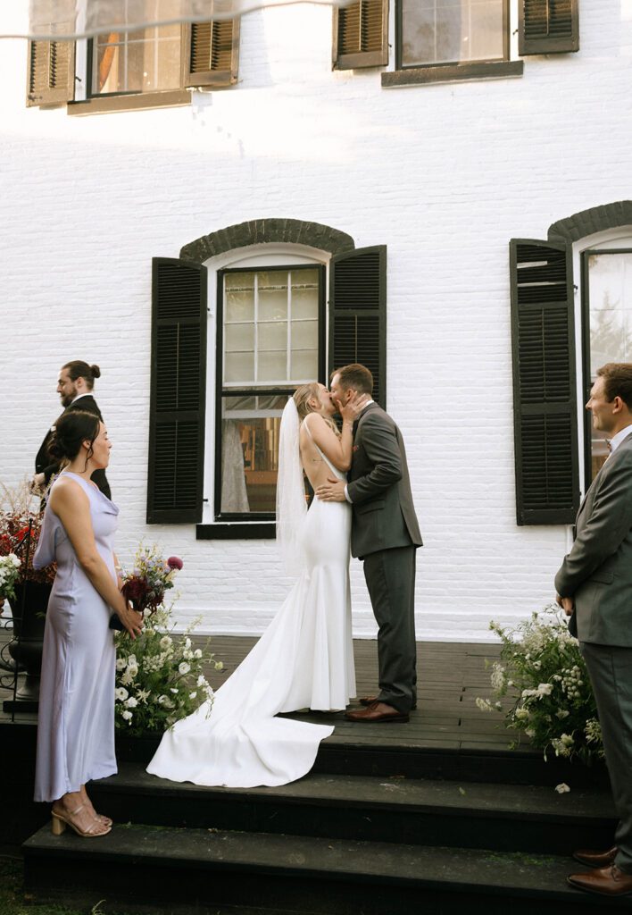 cute picture of the bride and groom kissing after their ceremony 