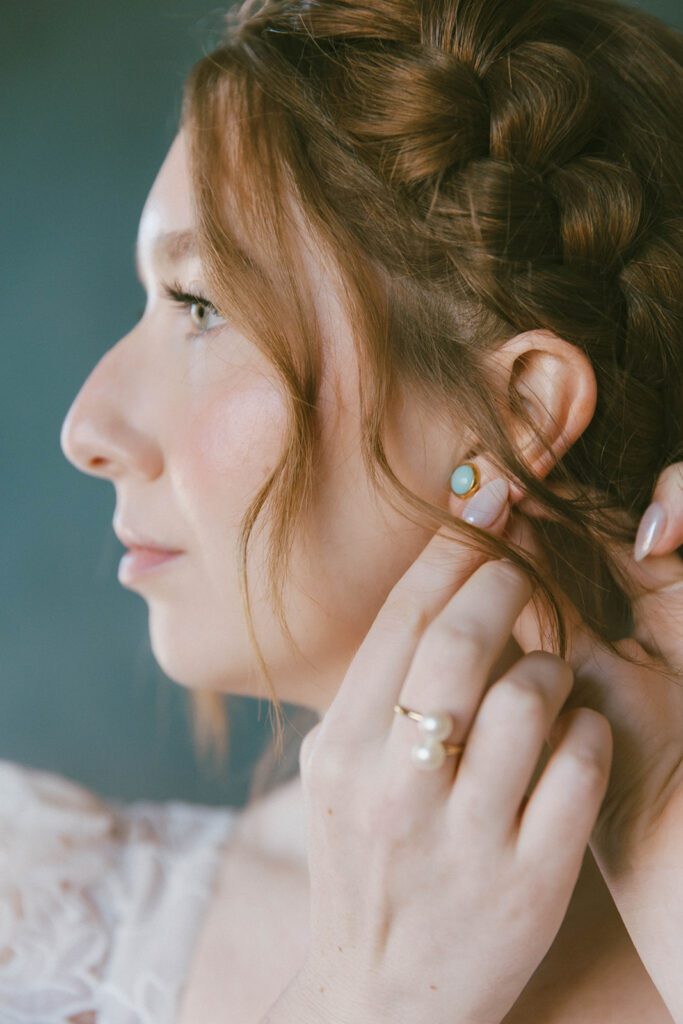 Bride putting on her jewelry before the ceremony