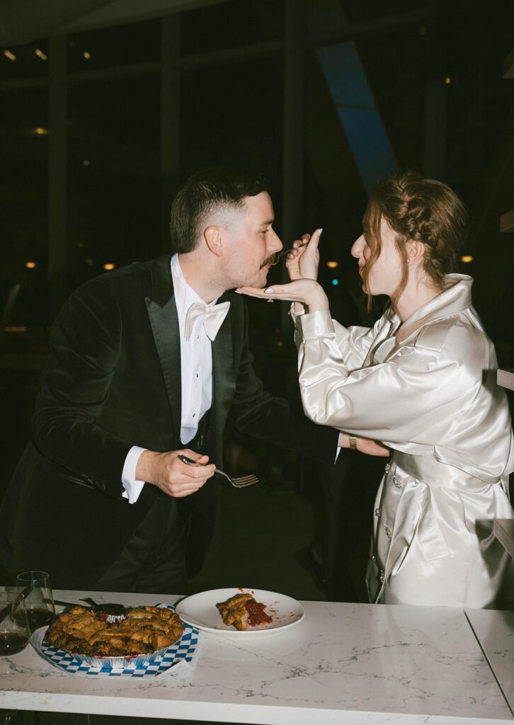 couple trying their wedding cake at their reception party