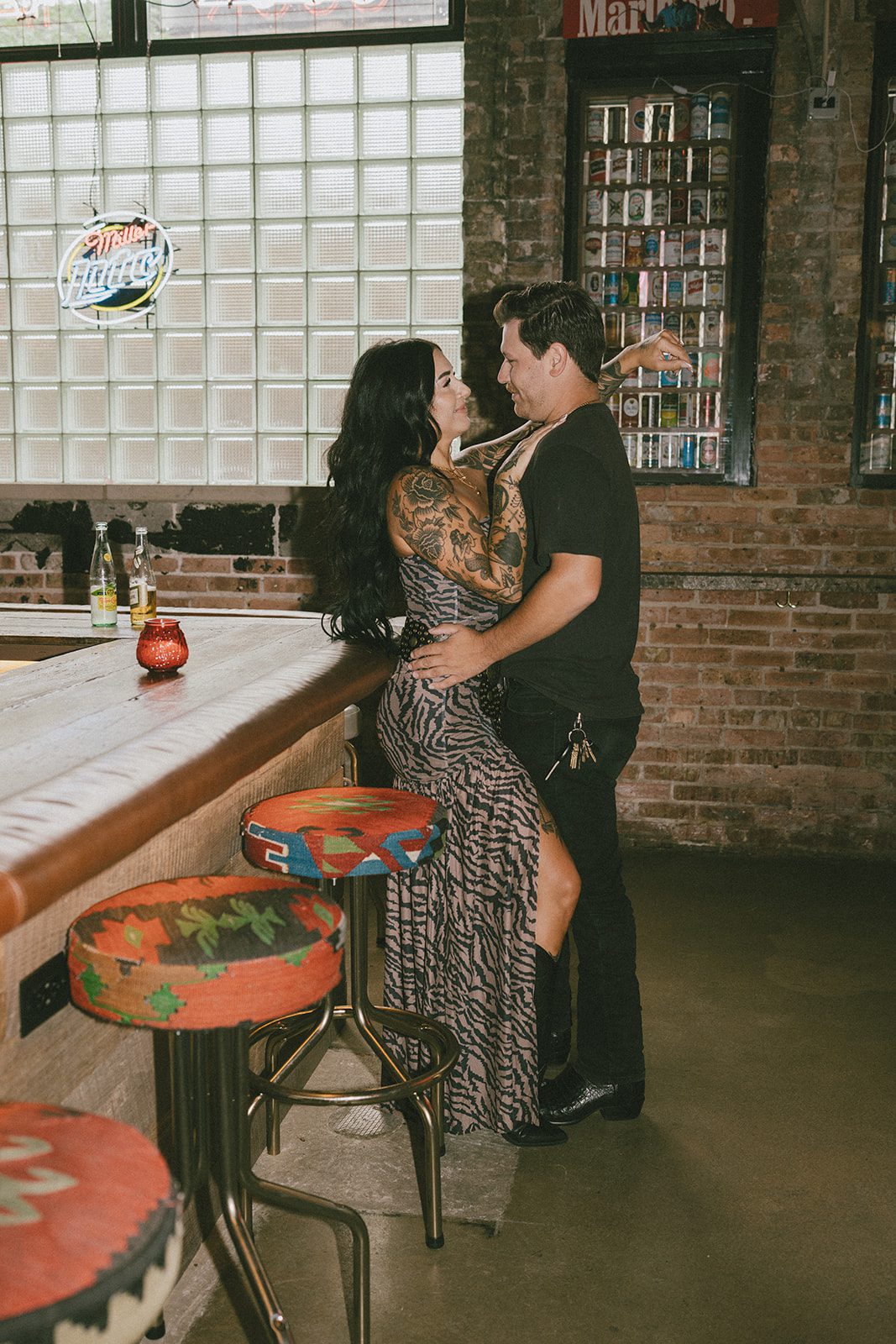 A couple smiling at each other in bar engagement photos
