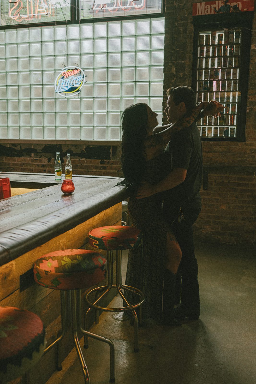 A couple smiling at each other at a bar for couples photos