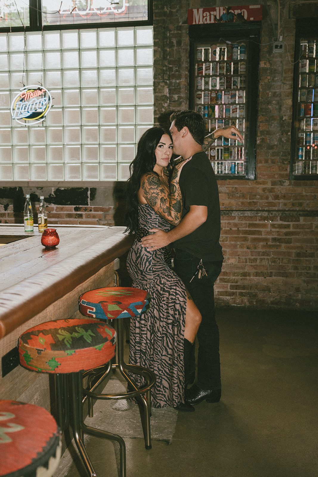 A girl leaning her head against her fiance at a bar