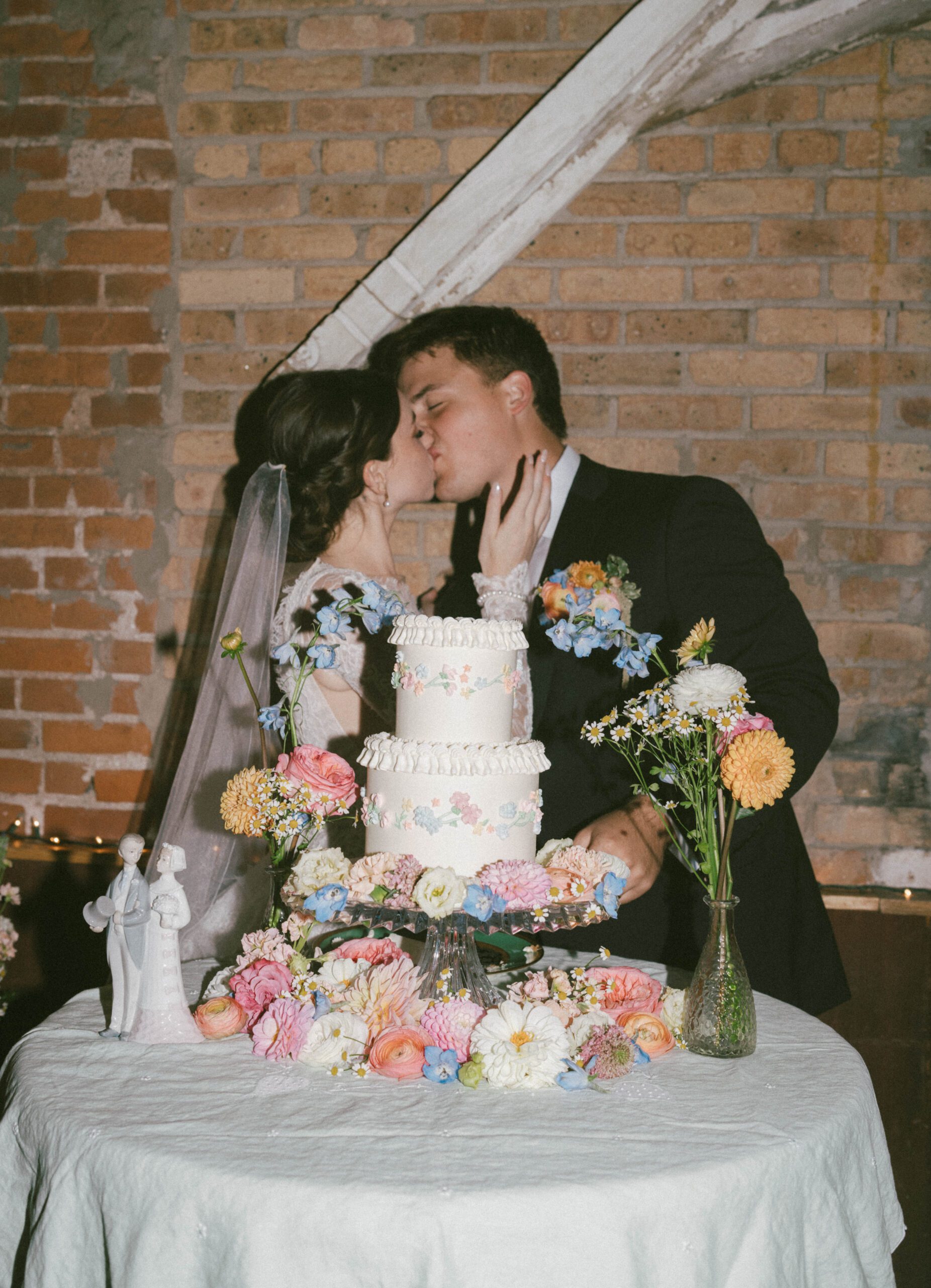 A couple kissing after their cake cutting