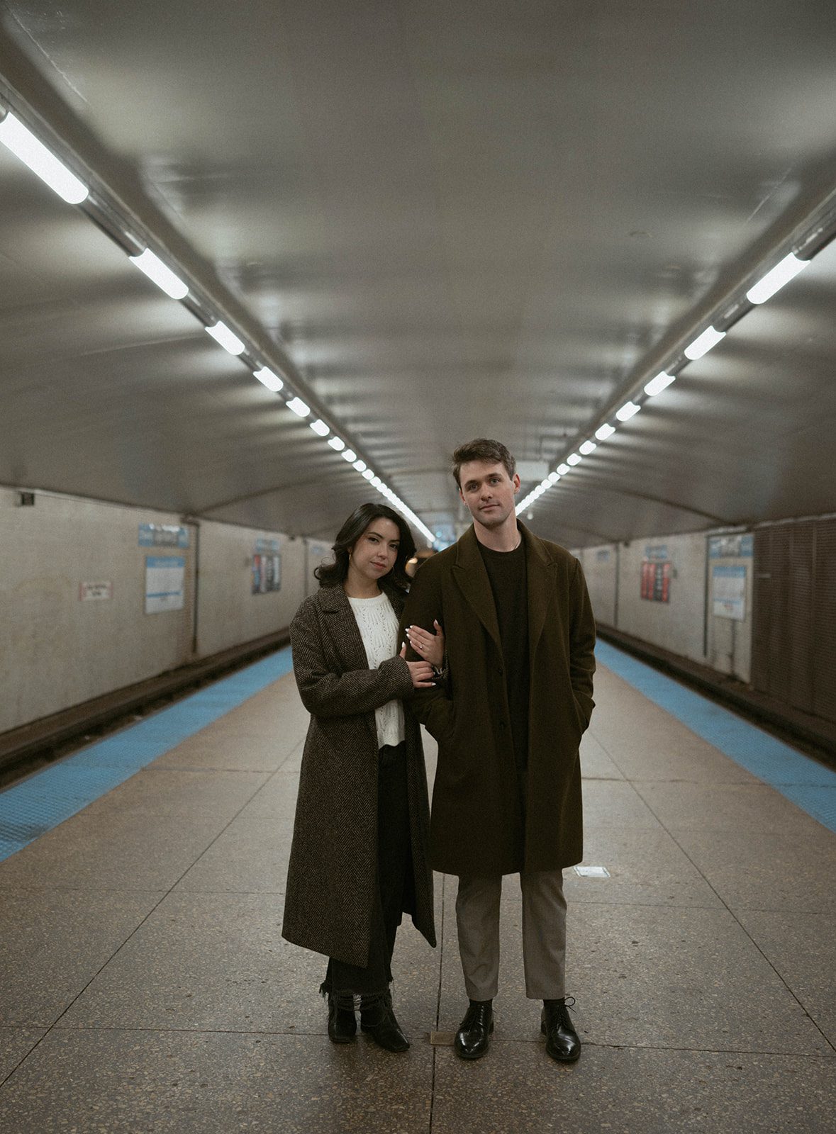 A couple standing in a subway station for engagement photoshoot ideas