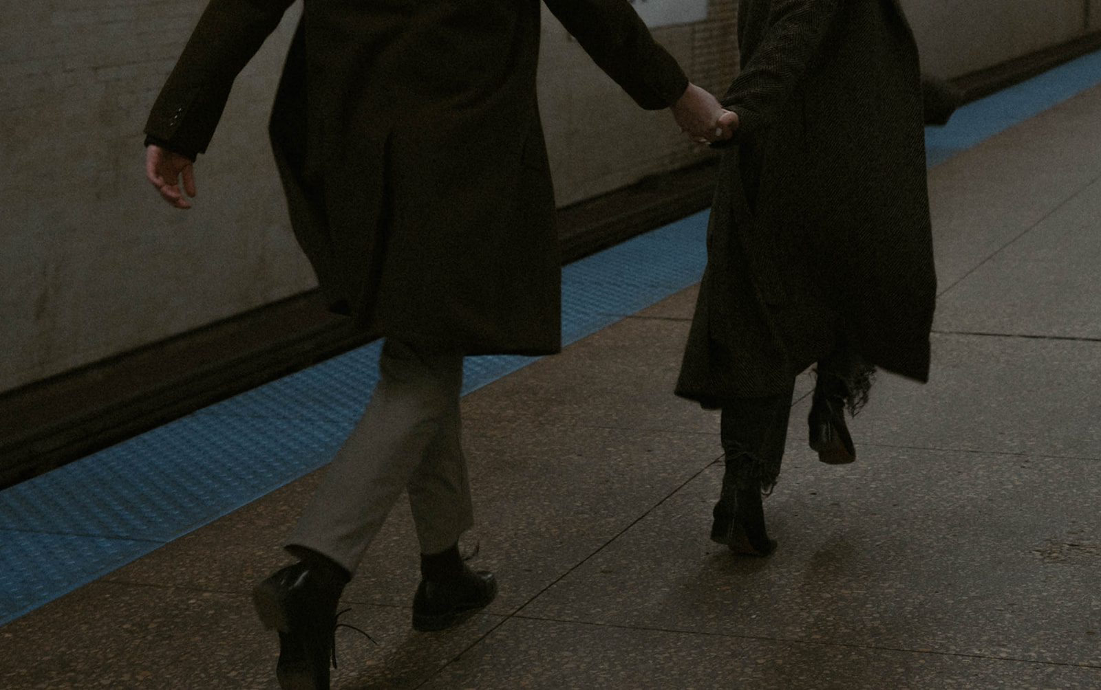 A couple running through a subway station as engagement photoshoot ideas