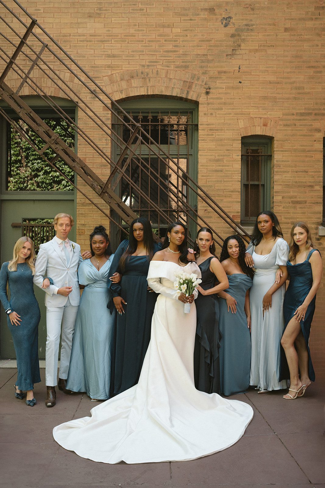 Bridesmaids in blue bridesmaid dresses posing with the bride