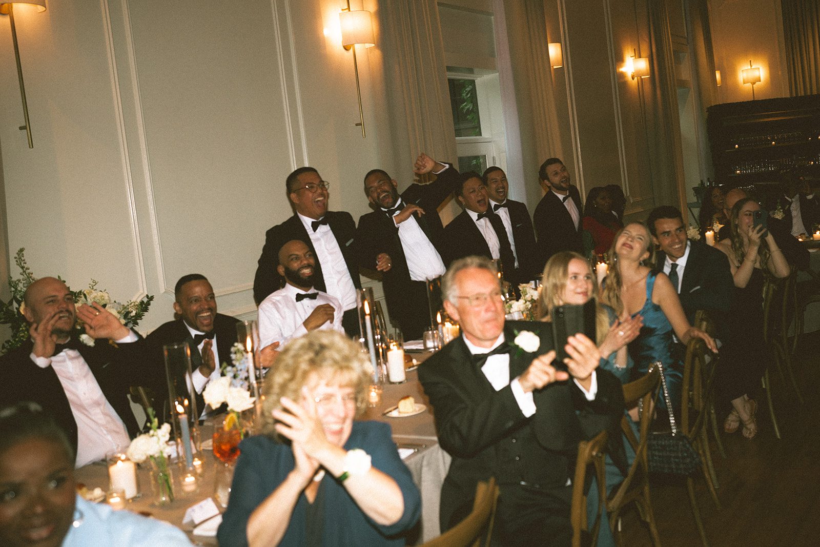 A candid photo of guests reacting to a bride and groom dancing