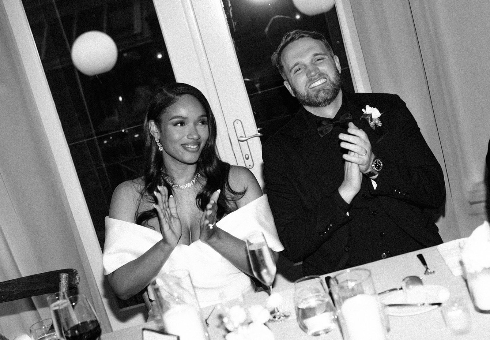 A black and white photo of a bride and groom at their wedding reception