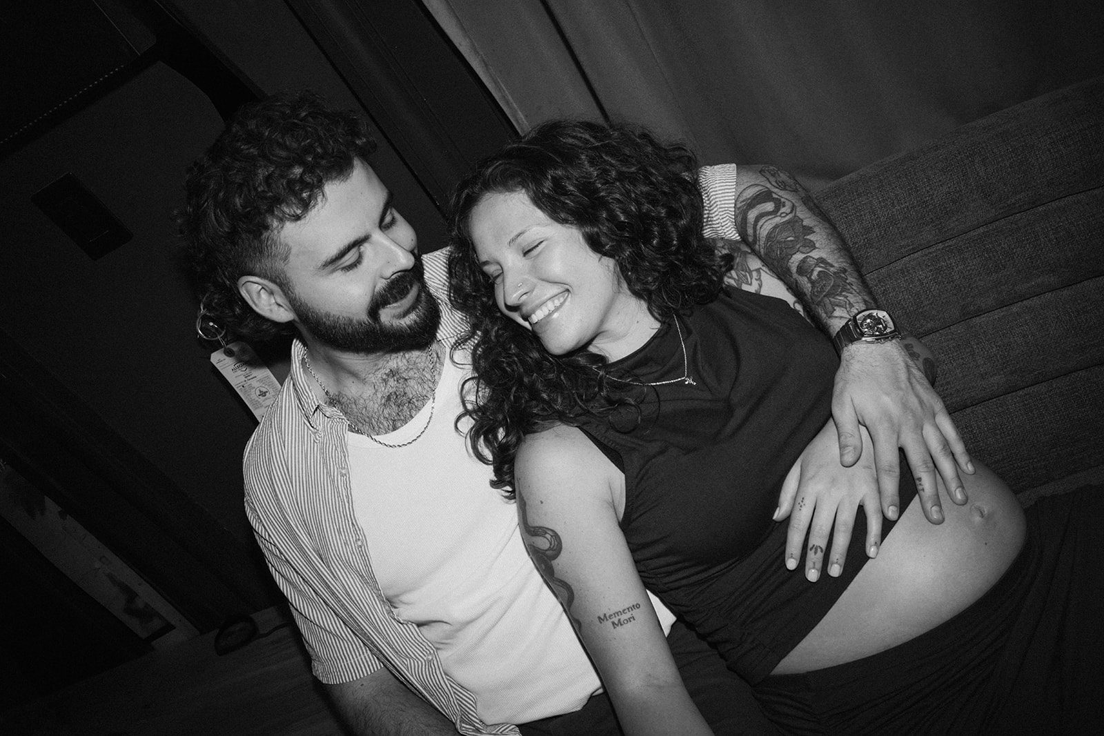 A black and white photo of a couple posing for maternity photos