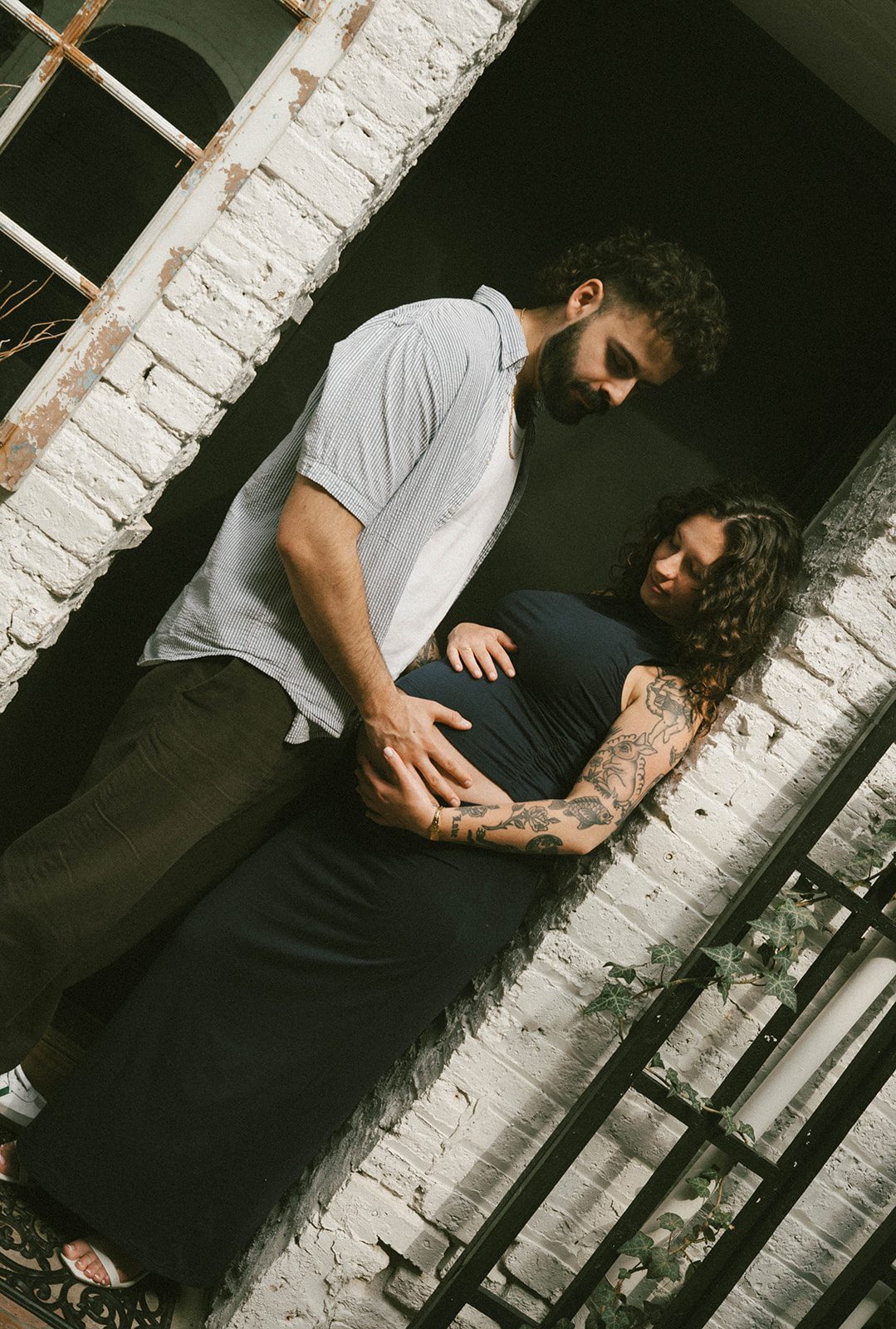 A couple standing in a doorway during a maternity photoshoot