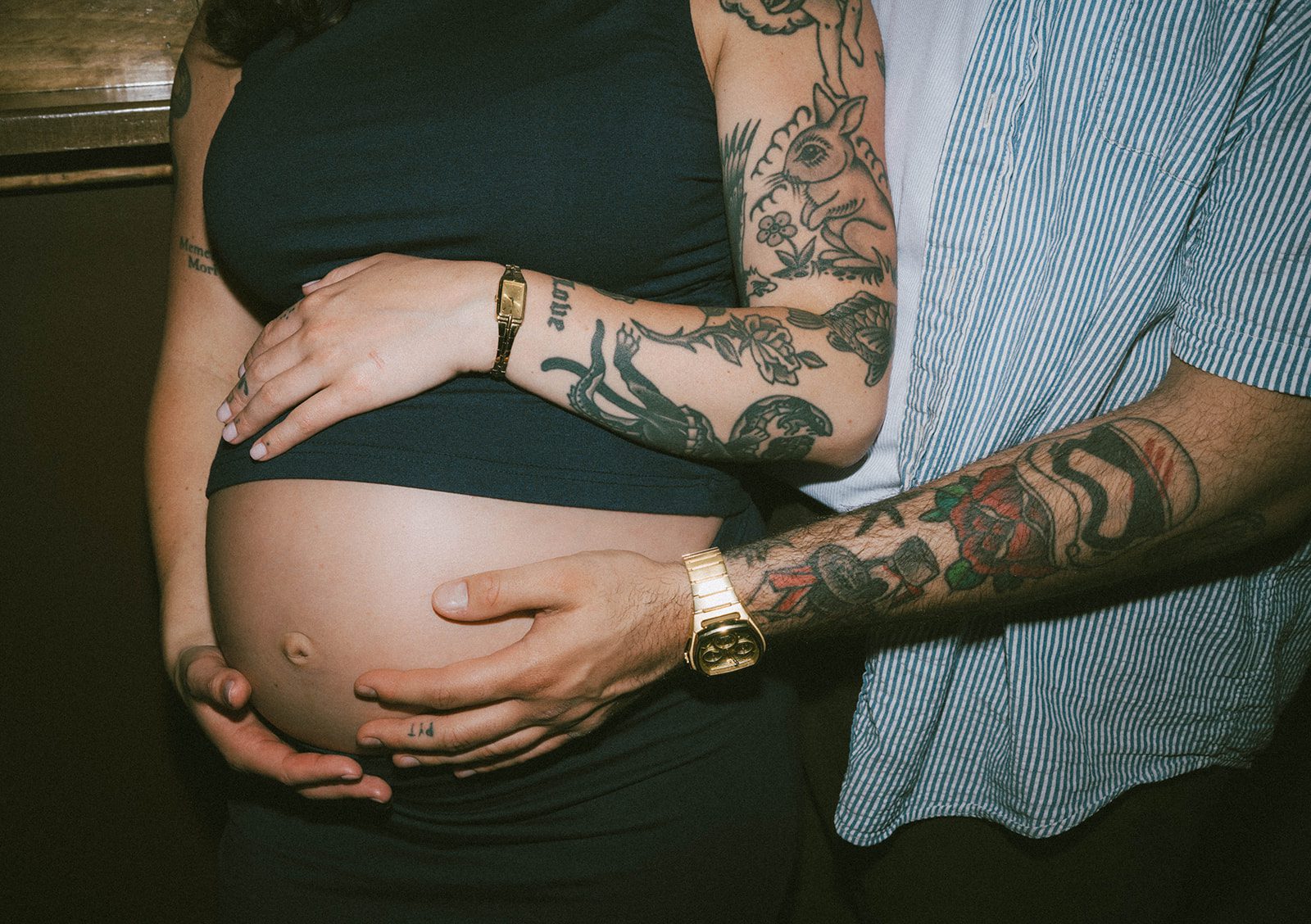 A couple holding a baby bump during maternity photos