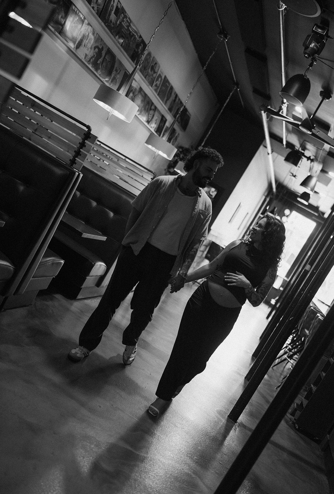 A couple walking through a restaurant for maternity photos