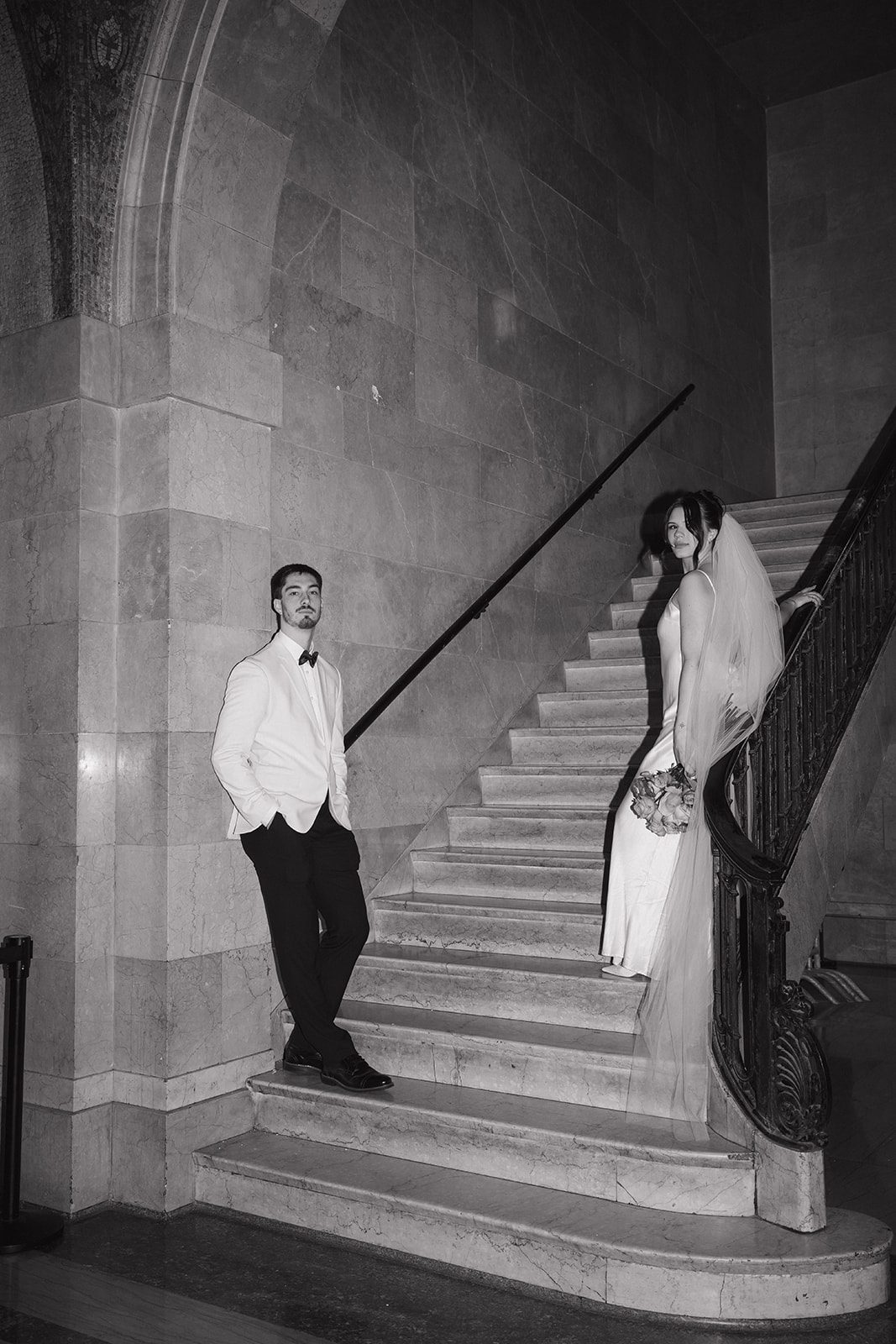 a couple posing on a marble staircase for chicago elopement photos