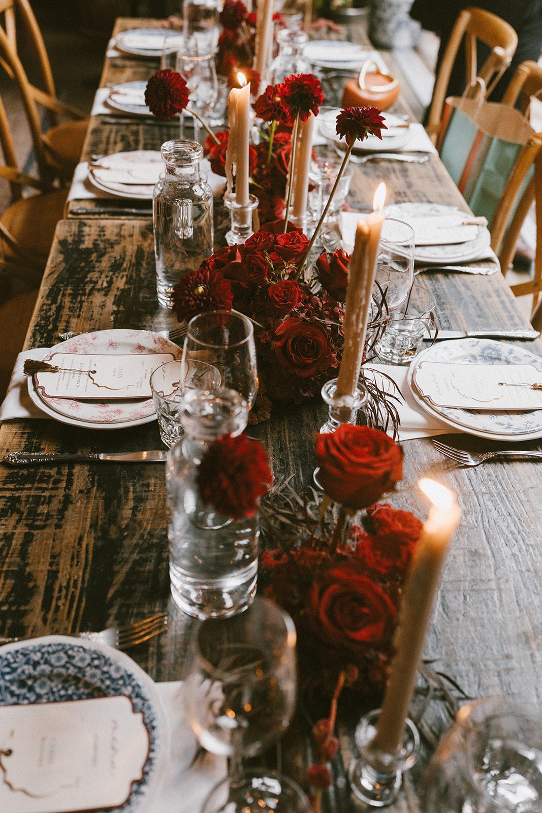 A candlelit wedding reception with red flowers