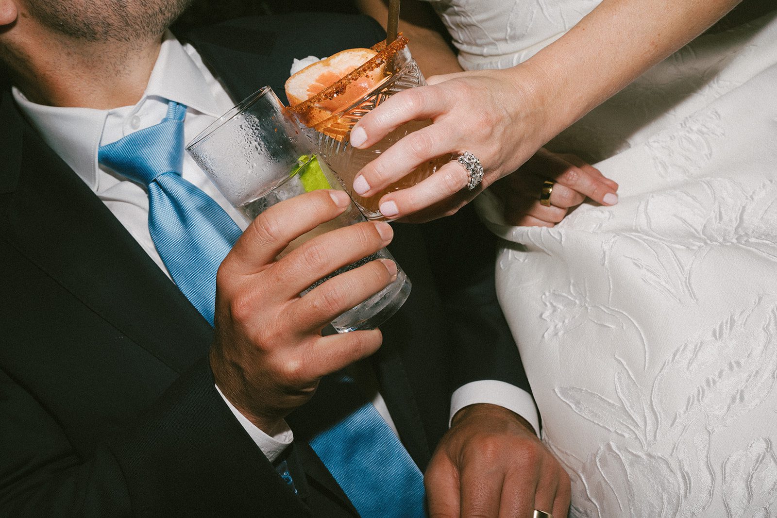 A bride and groom clinking glasses