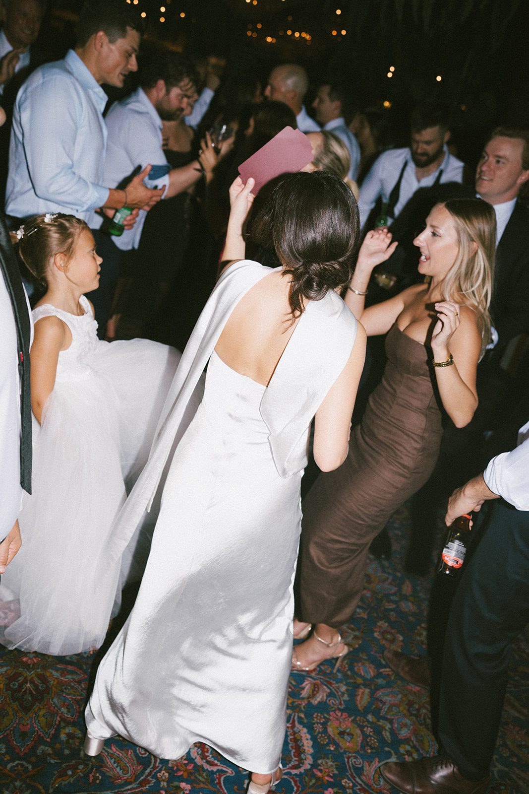 A candid wedding reception photo of a bride dancing