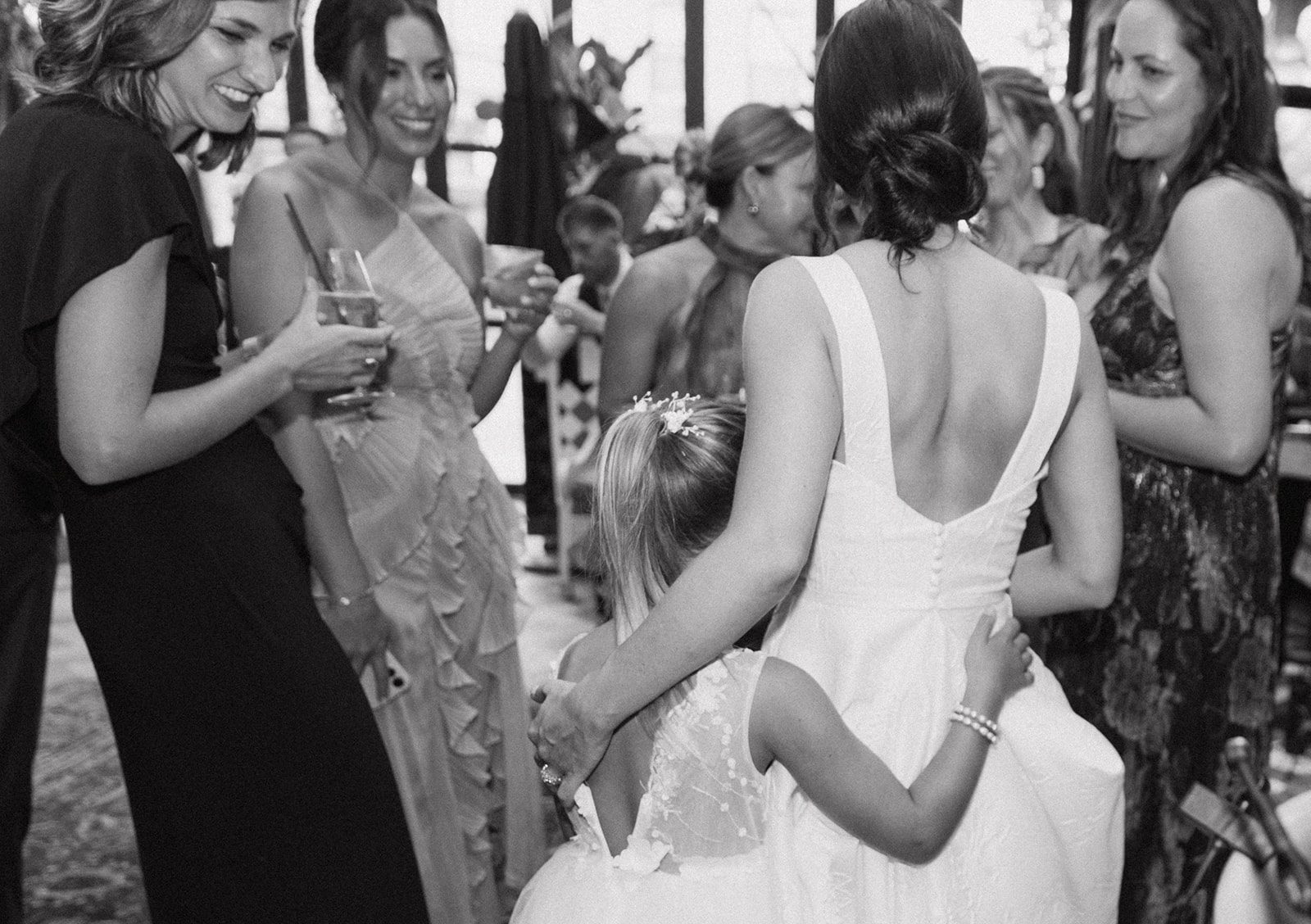 A bride hugging a little girl at her wedding reception