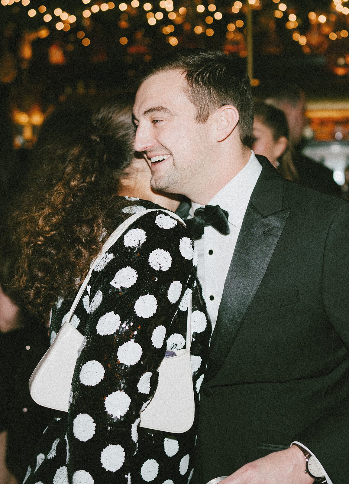 A groom hugging a wedding guest