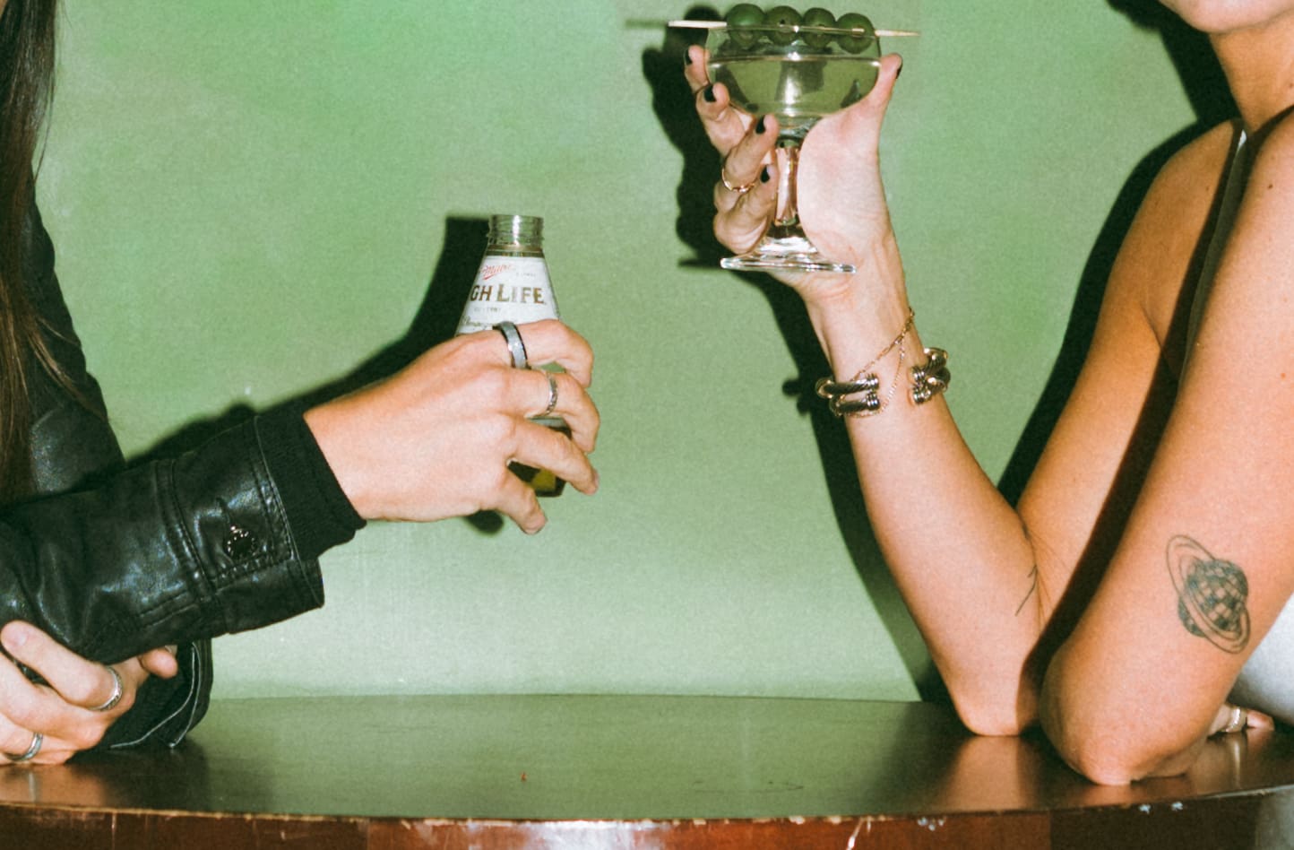 A couple each holding a drink at a bar