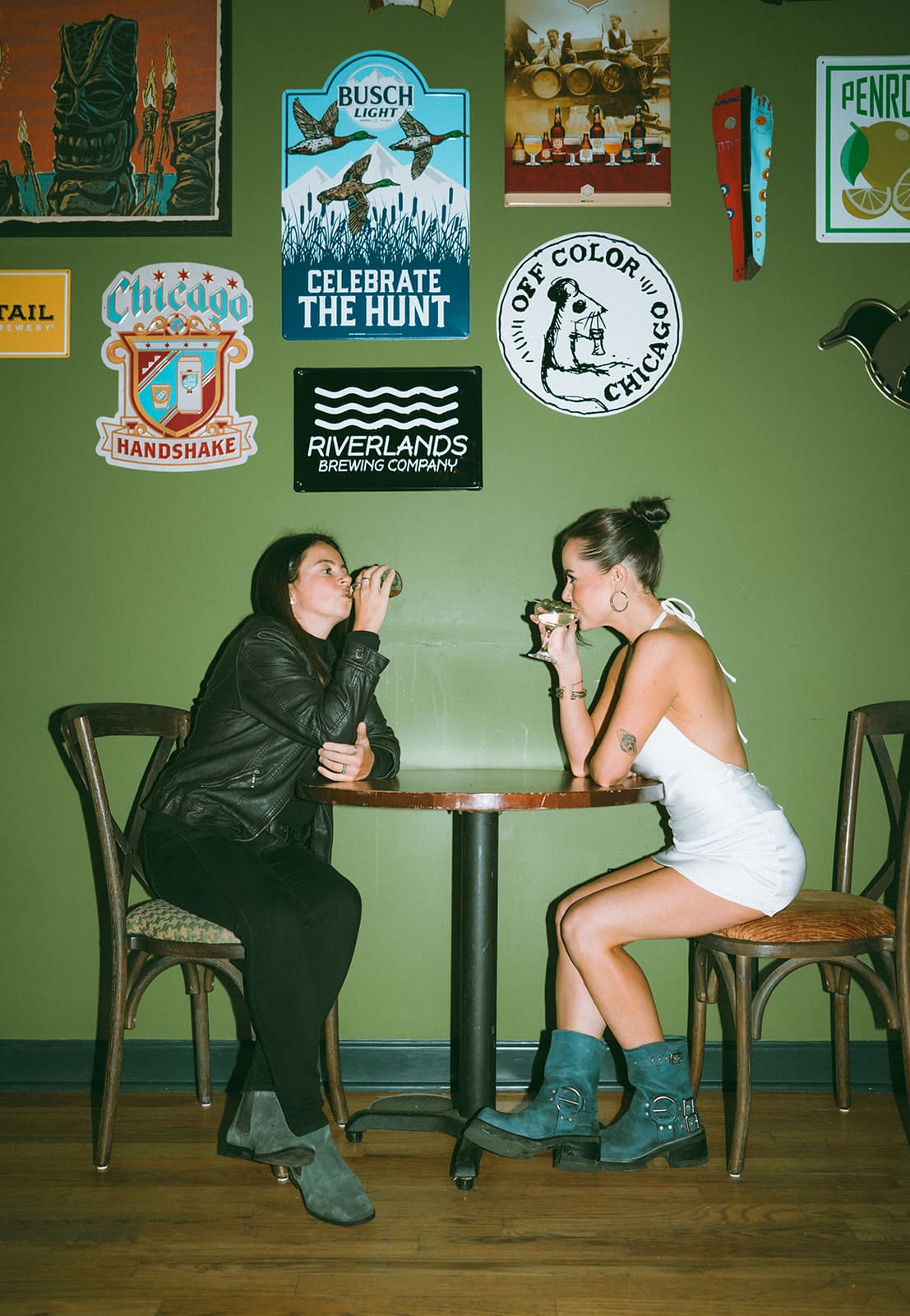  A couple sitting at a table at a bar, each drinking a beverage
