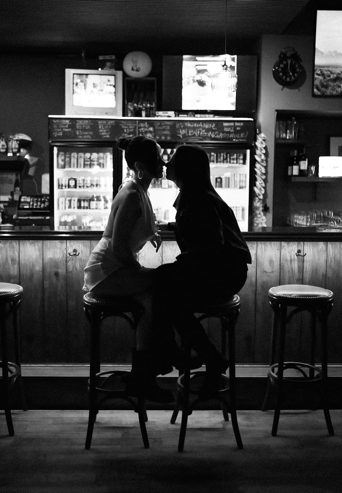 A couple posing for engagement photoshoot ideas at a bar