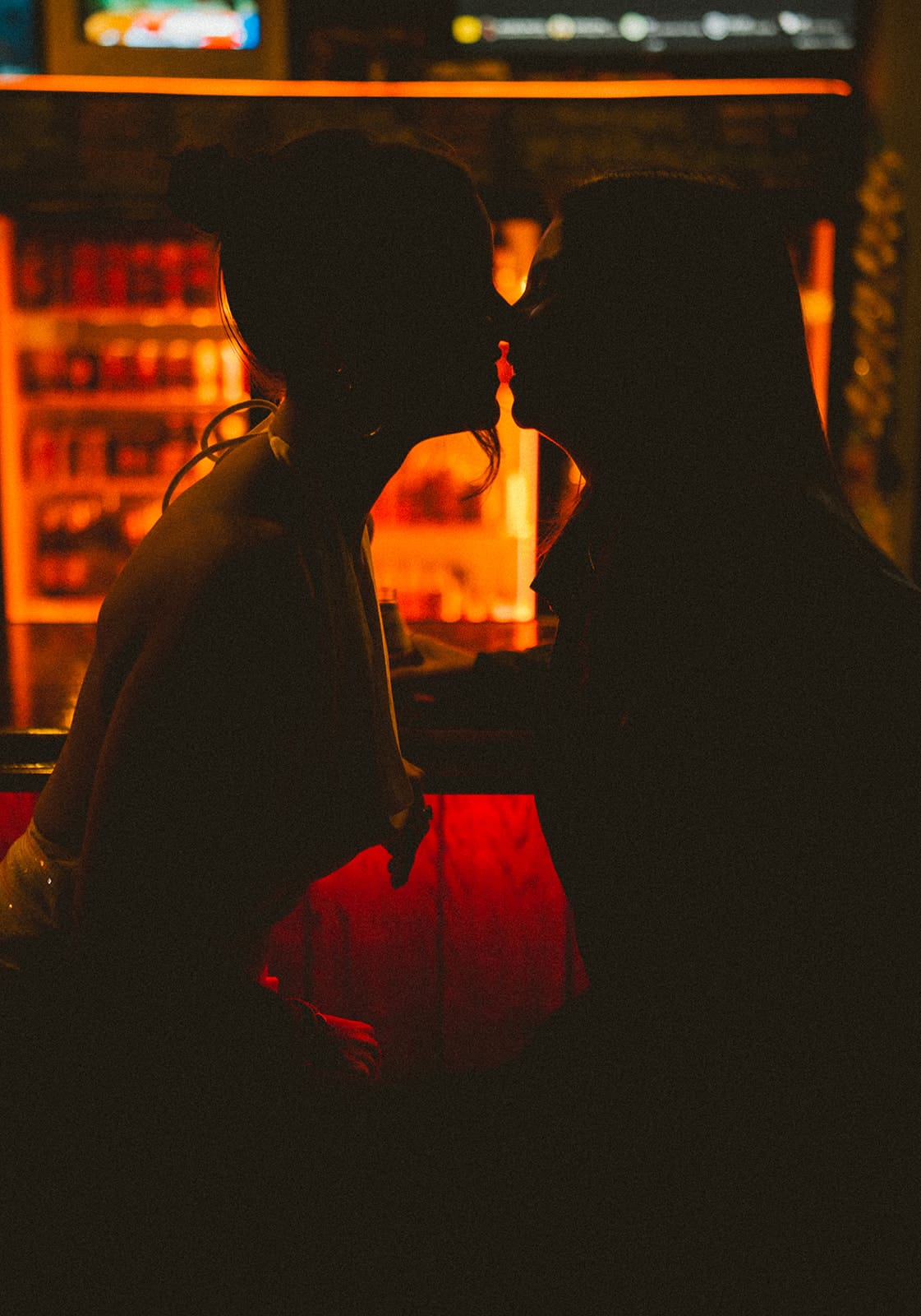 A couple sitting at a bar for their engagement photos, a great engagement photoshoot idea