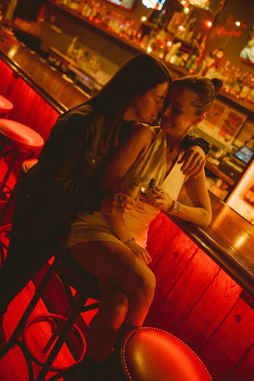 A couple posing for engagement photoshoot ideas at a bar 