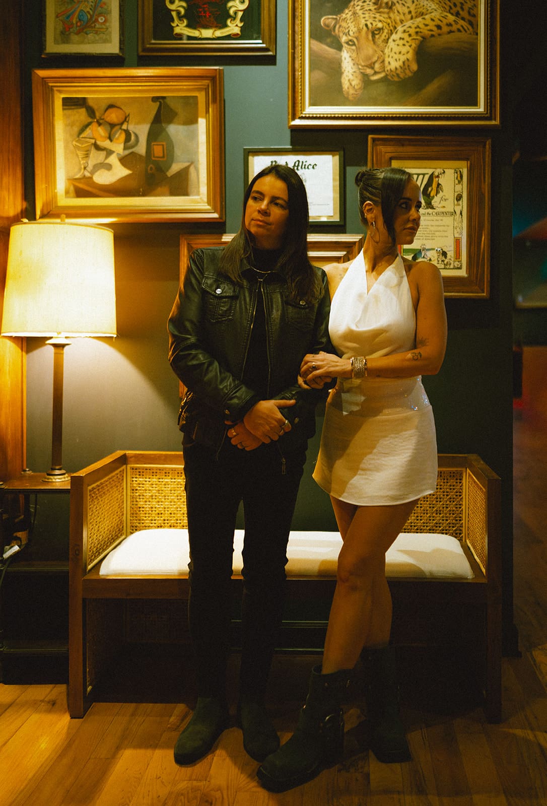 A couple posing in front of a gallery wall