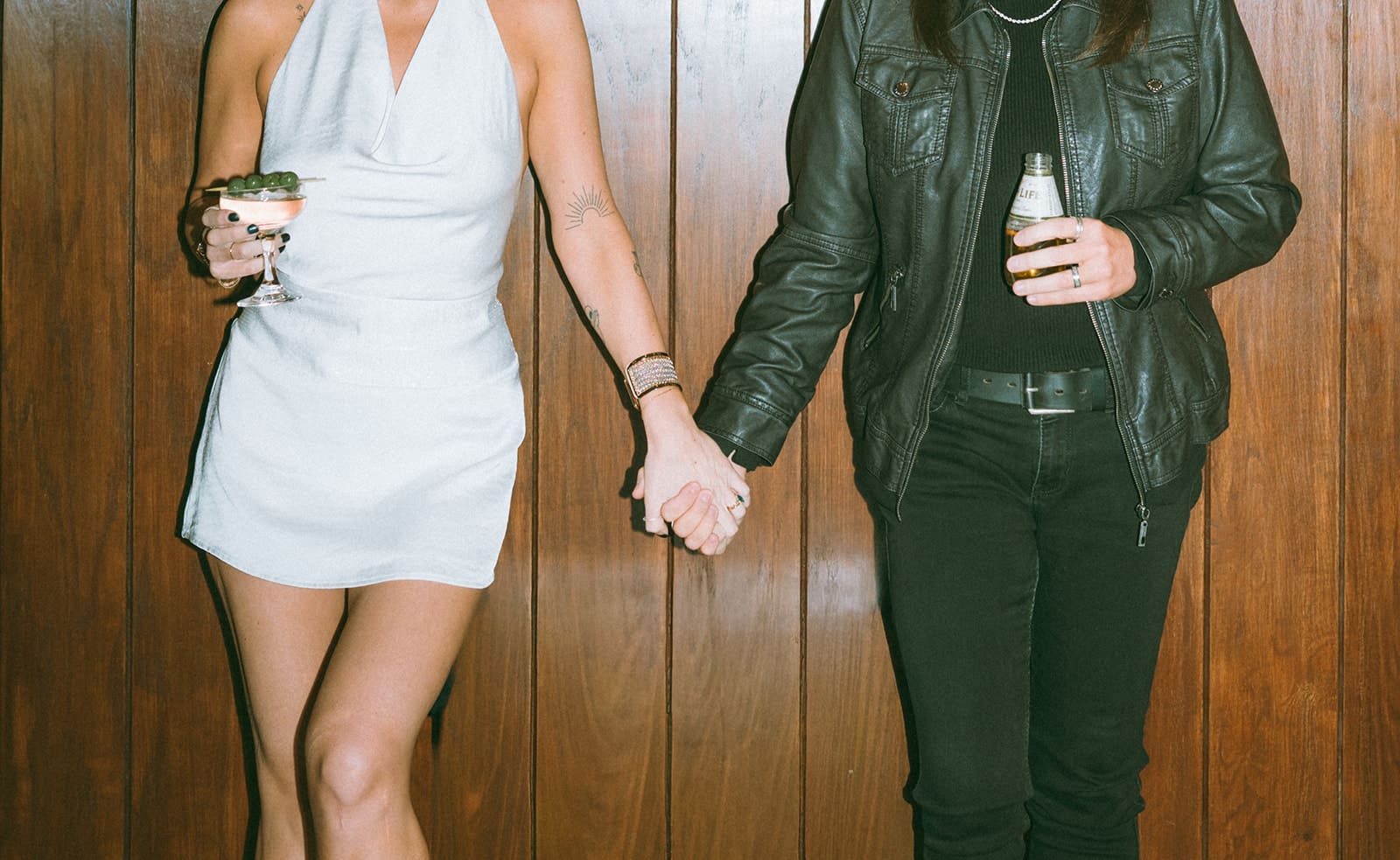 A couple posing, showing off their bar engagement photos outfits