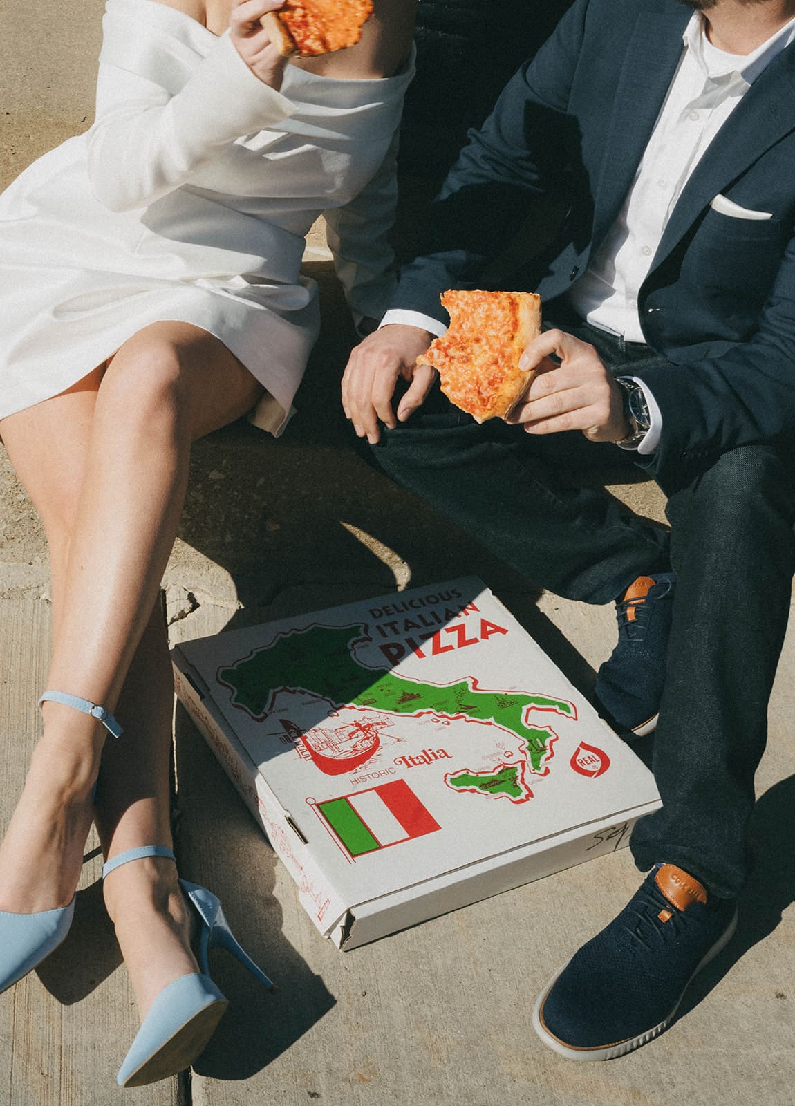 A couple eating pizza during their engagement photos