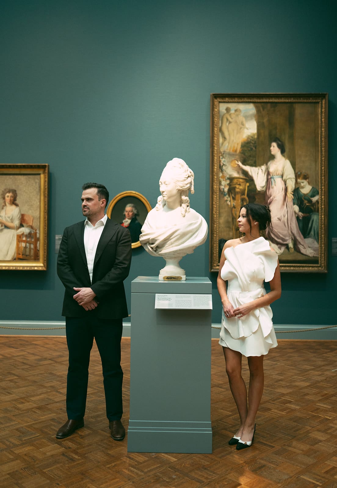 A couple taking engagement photos in an Art Museum