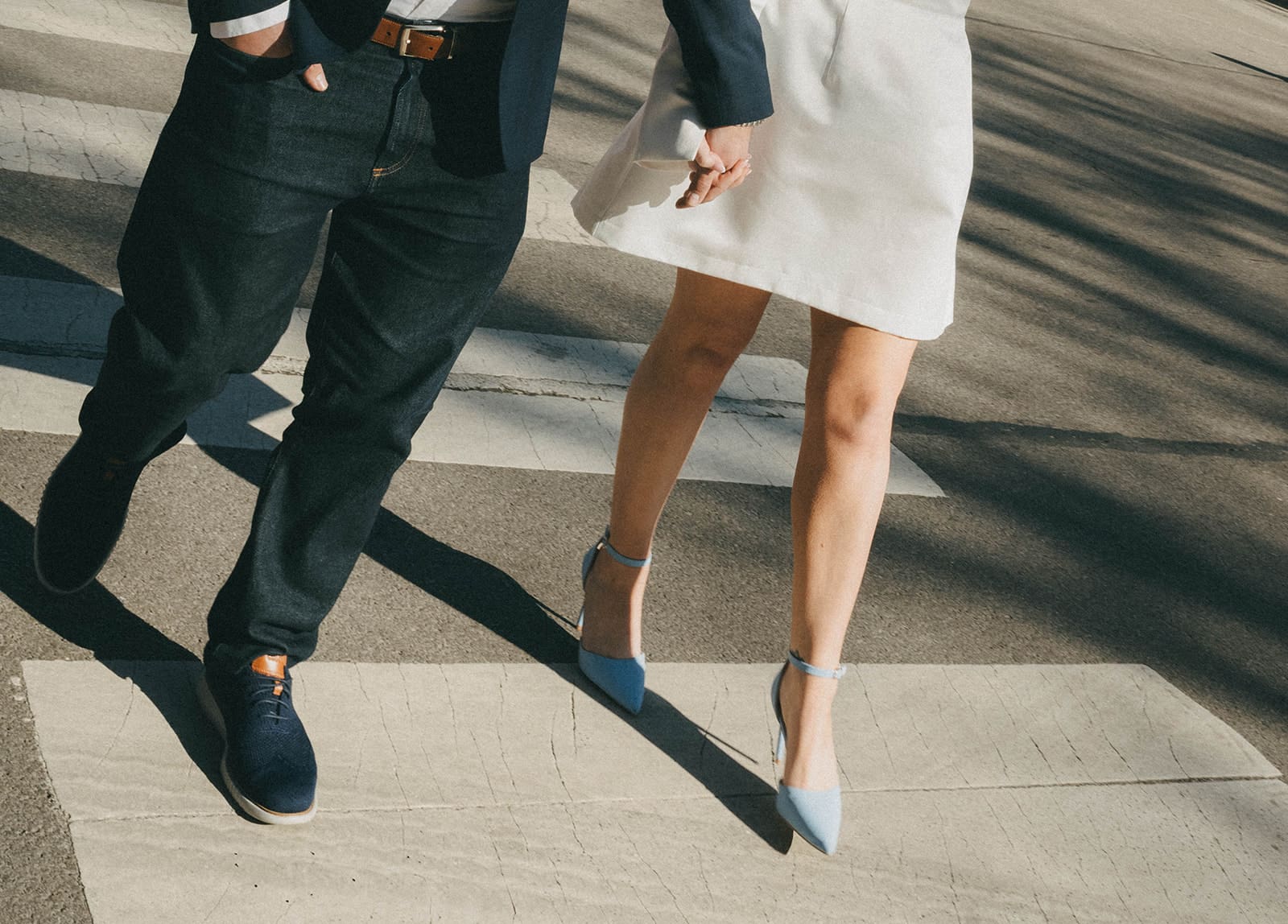 A couple's feet as they're crossing the street in their engagement photo outfits