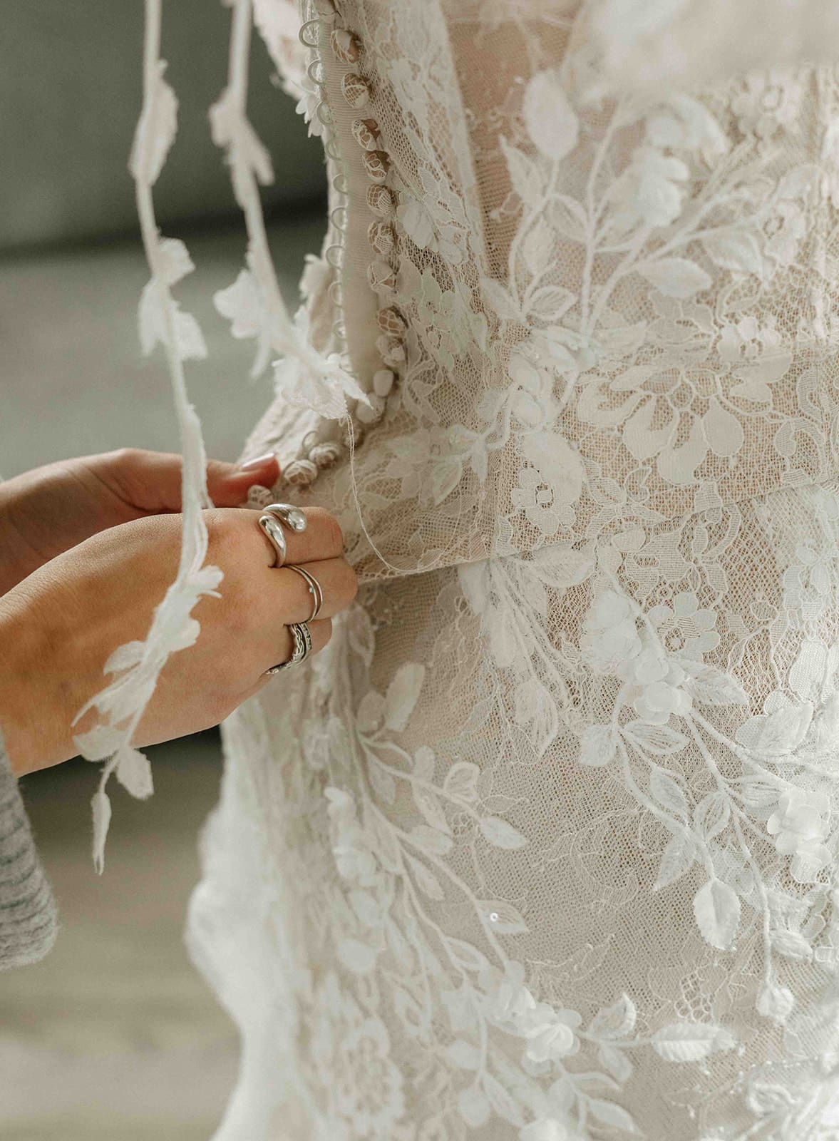 A bride putting on her wedding dress during the getting ready portion of the day of wedding timeline