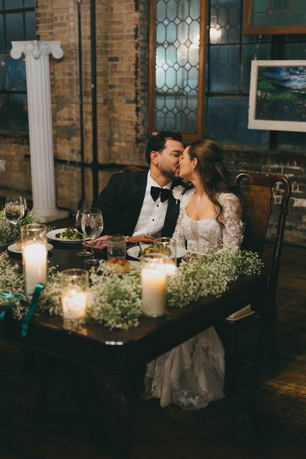 A bride and groom kissing during the wedding reception part of their day of wedding timeline