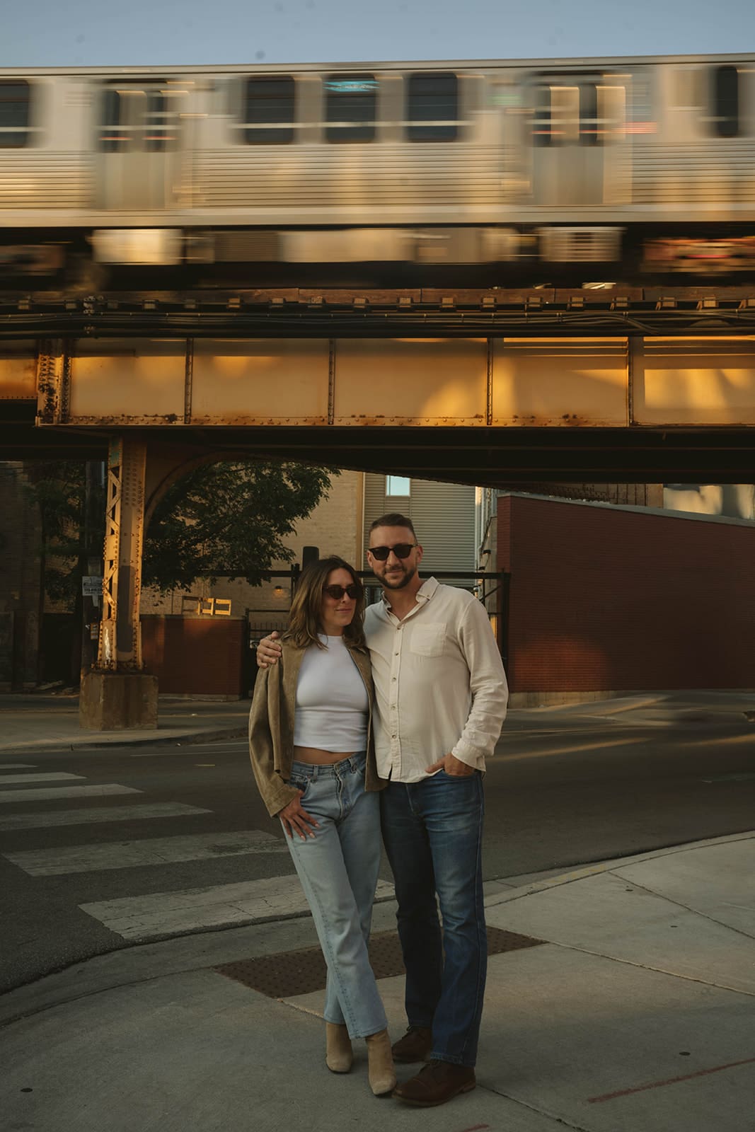A couple posing for engagement pictures in front of a subway train