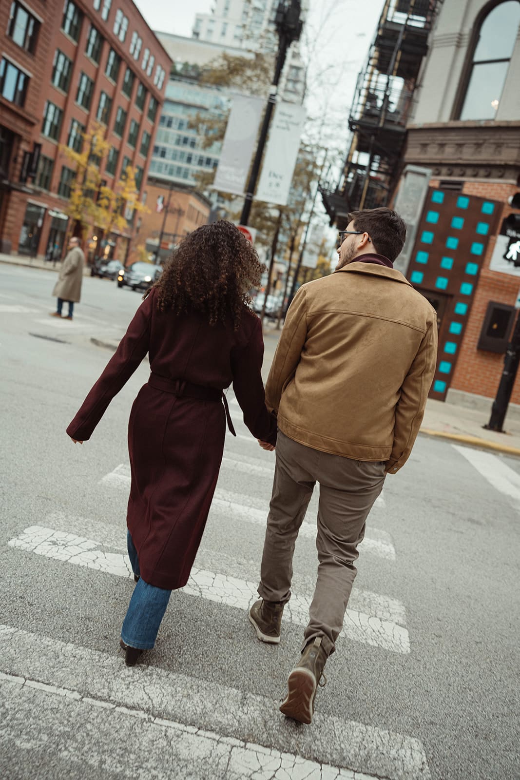 A couple posing for city engagement photos in Chicago