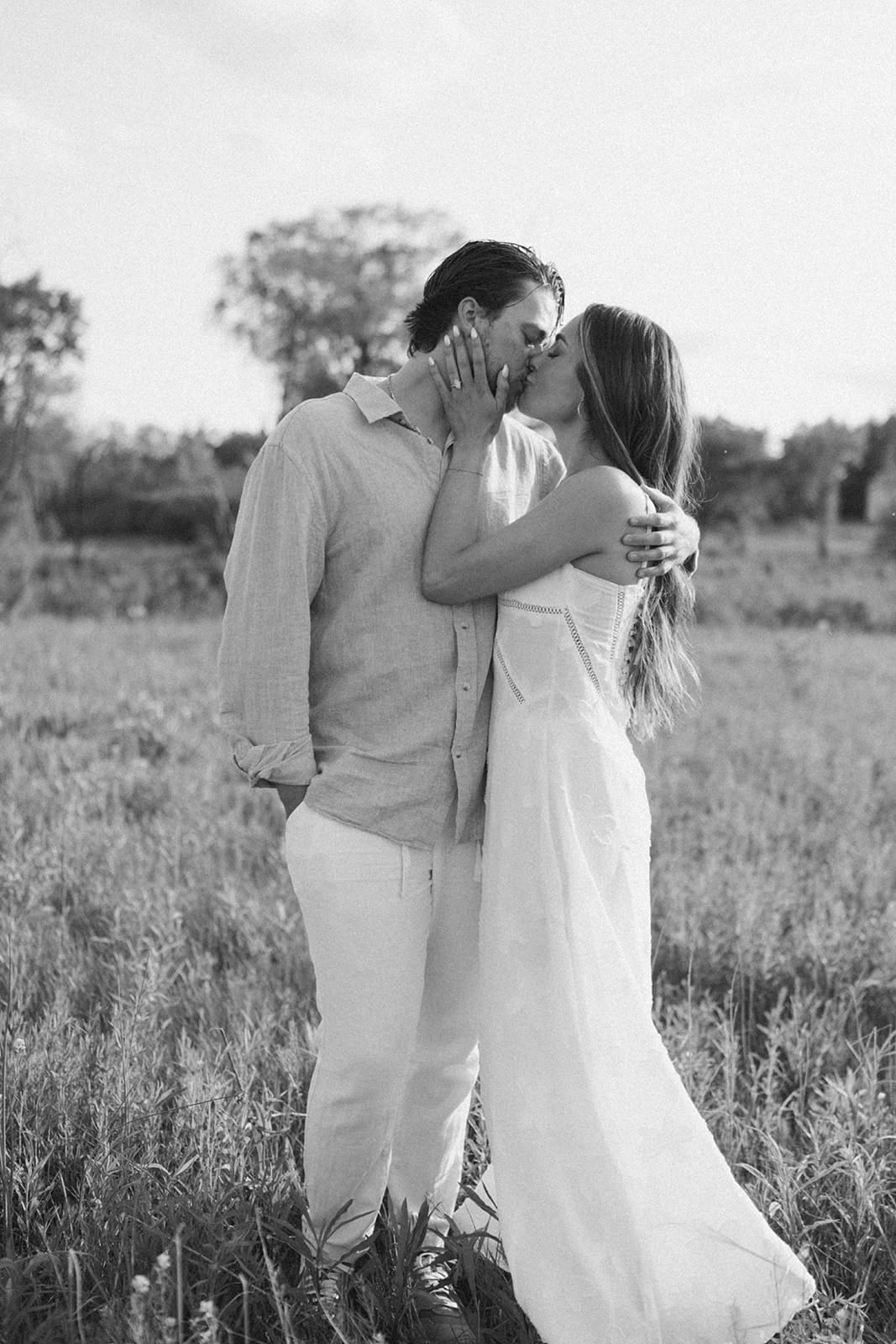 A couple kissing in a black and white engagement photo