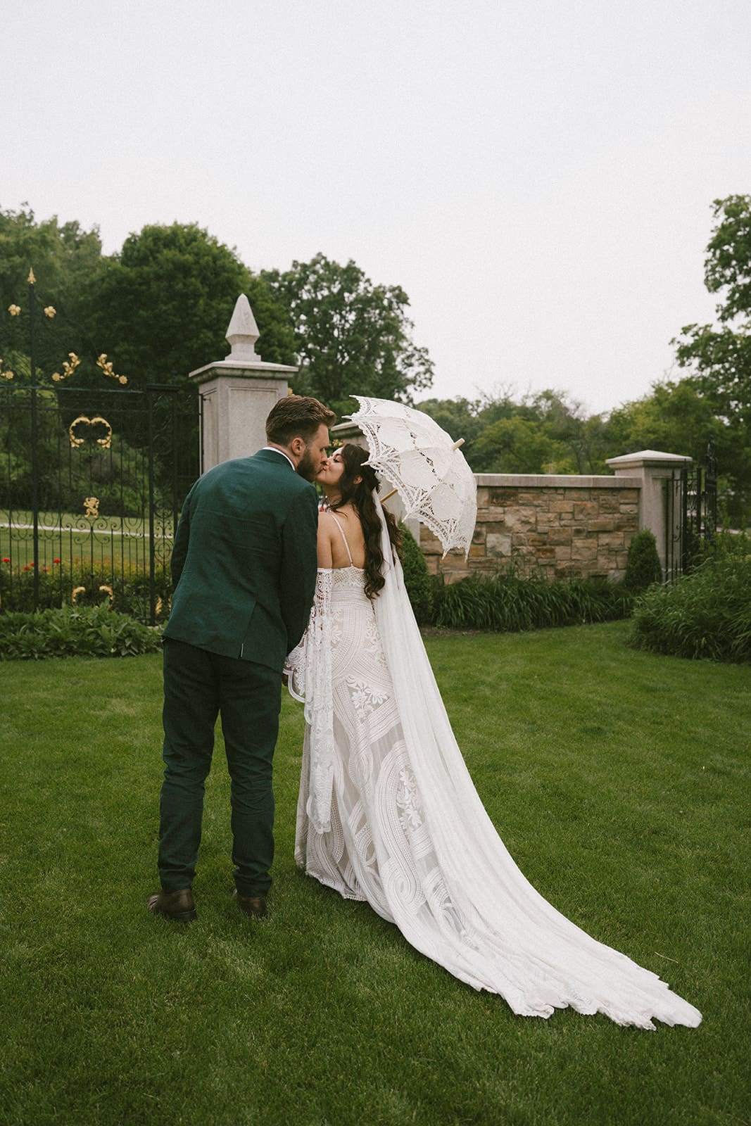 A couple posing for their fall Chicago wedding with a lace umbrella