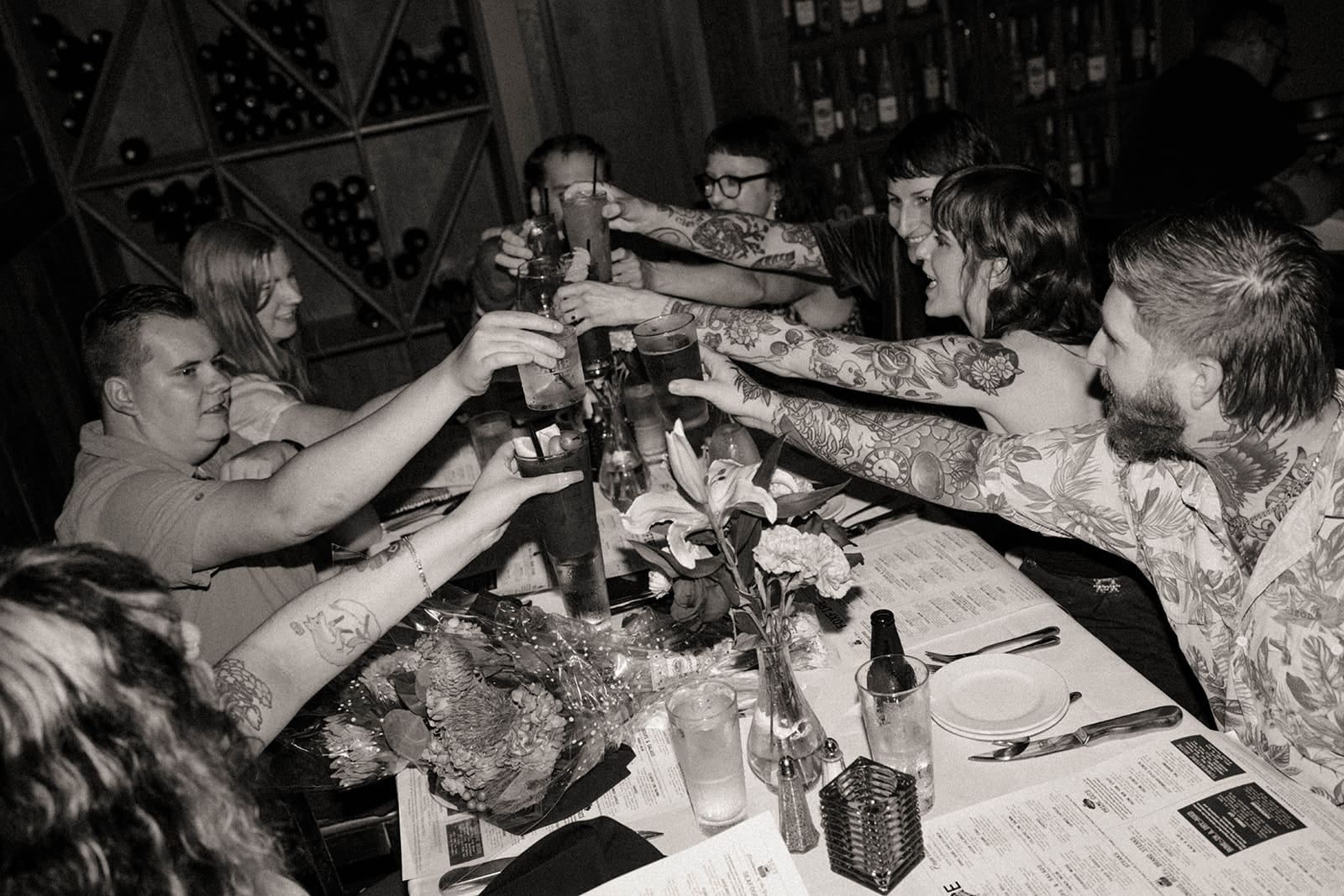 A crowd clinking drinks after a surprise proposal