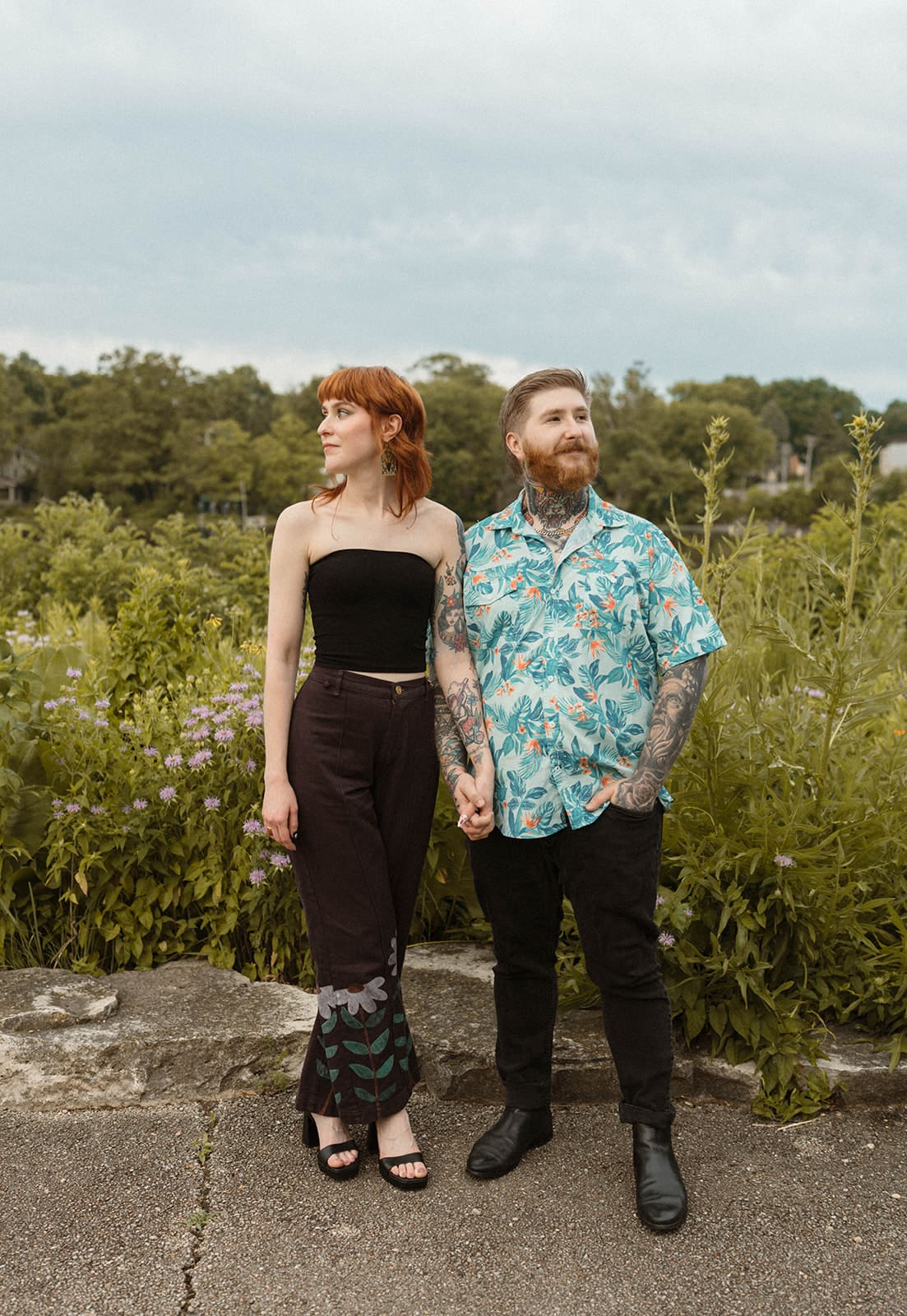 A couple posing for engagement photos outside