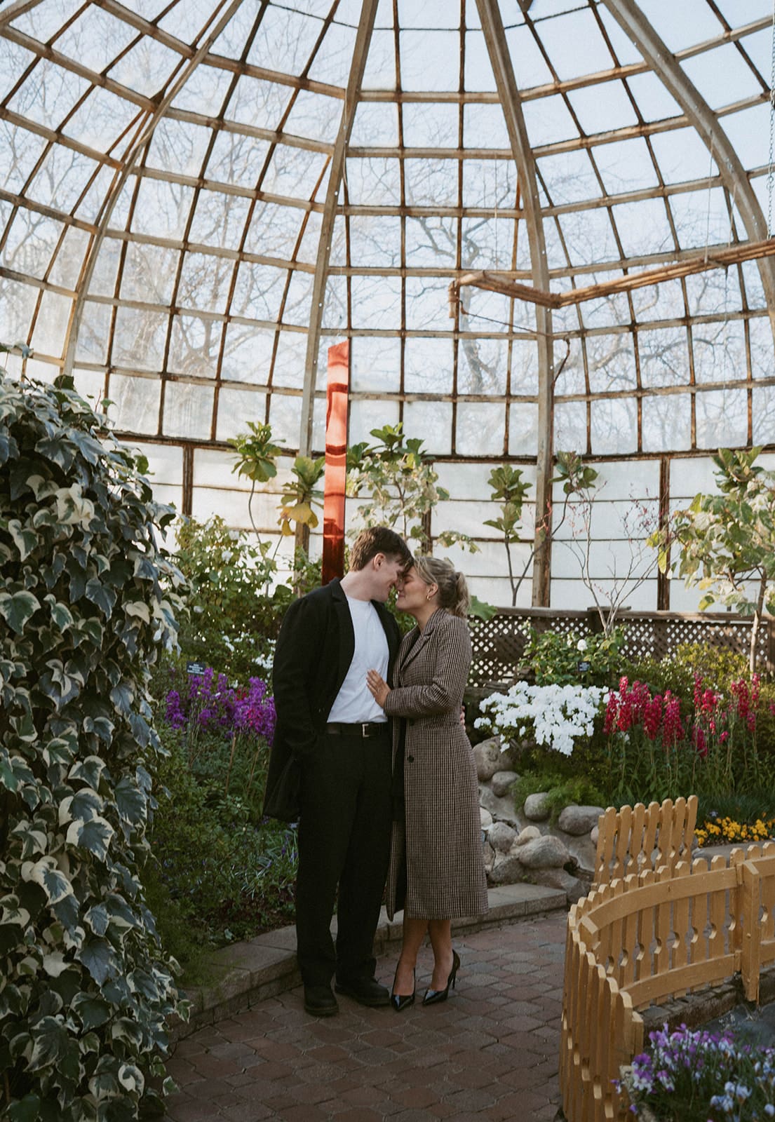 A couple posing for engagement pictures in a conservatory