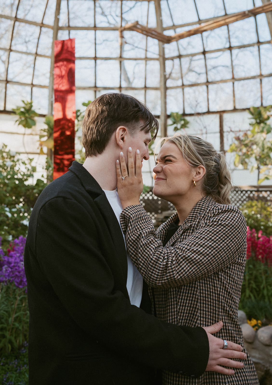 A couple posing for engagement pictures in a conservatory