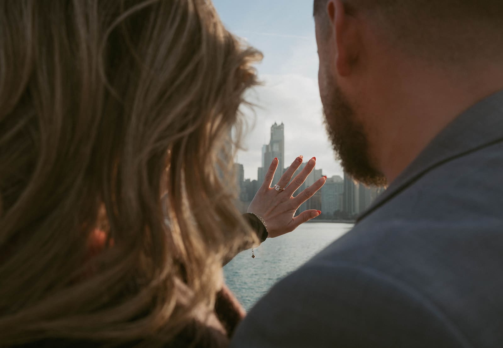A woman holding out her engagement ring after being proposed to in Chicago