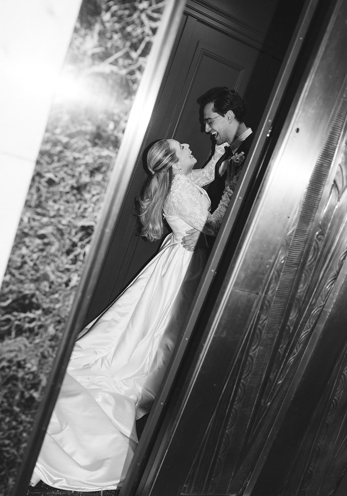 A bride and groom taking wedding photos in an elevator