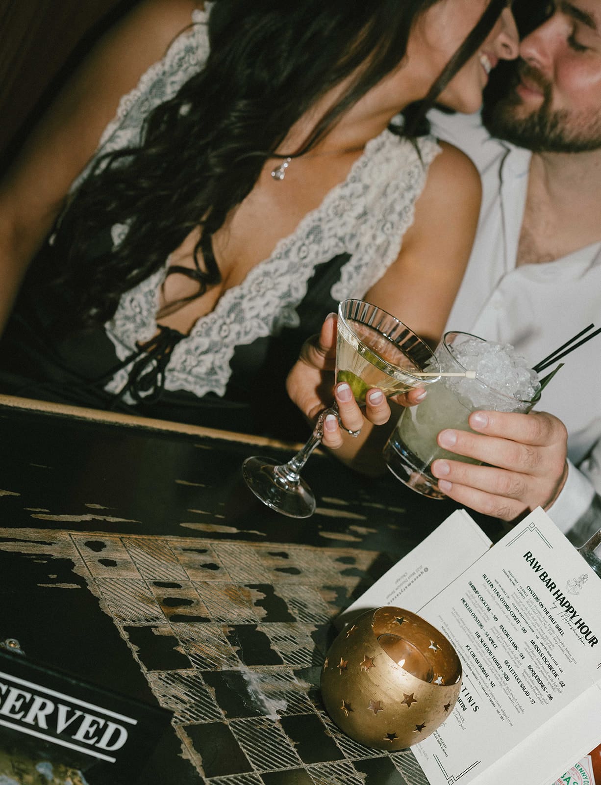 A couple taking bar engagement photos, showing when to take engagement photos
