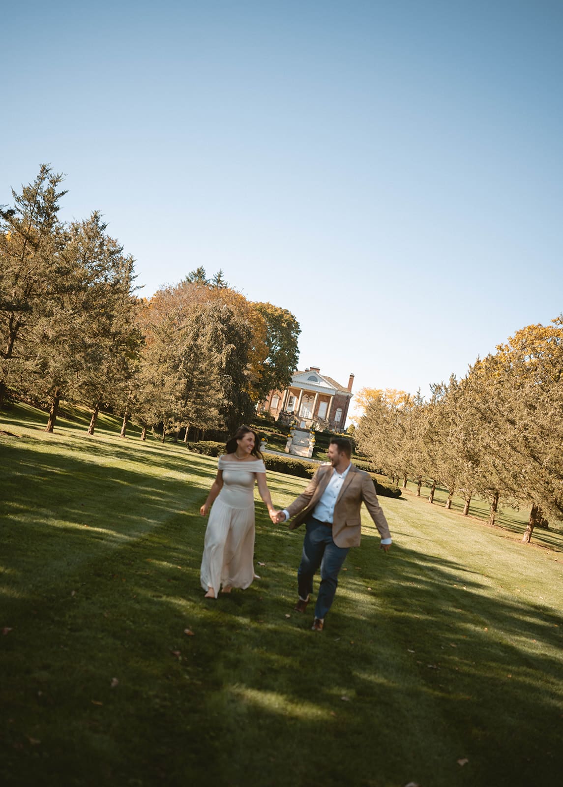 A couple running during their engagement photos in a blog about when to take engagement photos