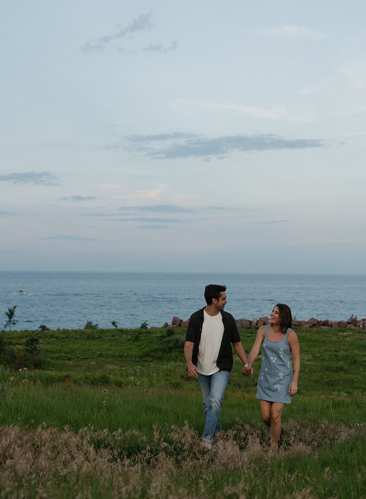A couple taking summer sunset engagement photos, showing when to take engagement photos