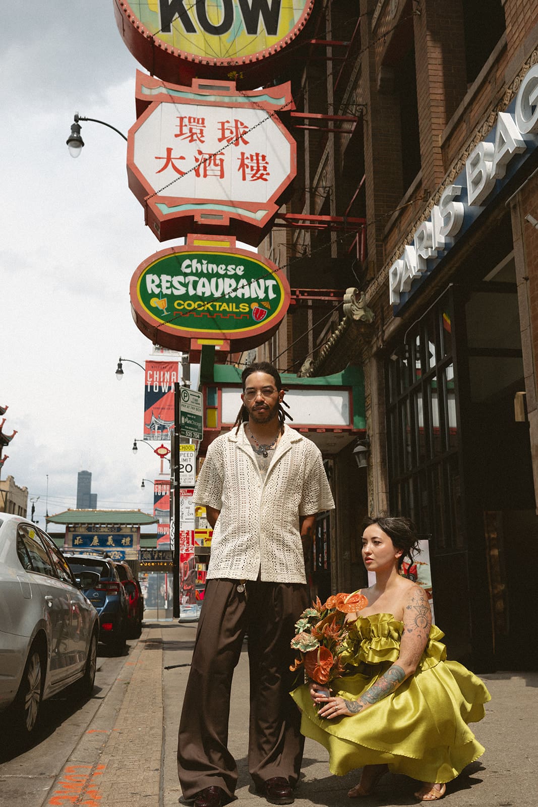 A couple taking summer engagement photos in chinatown