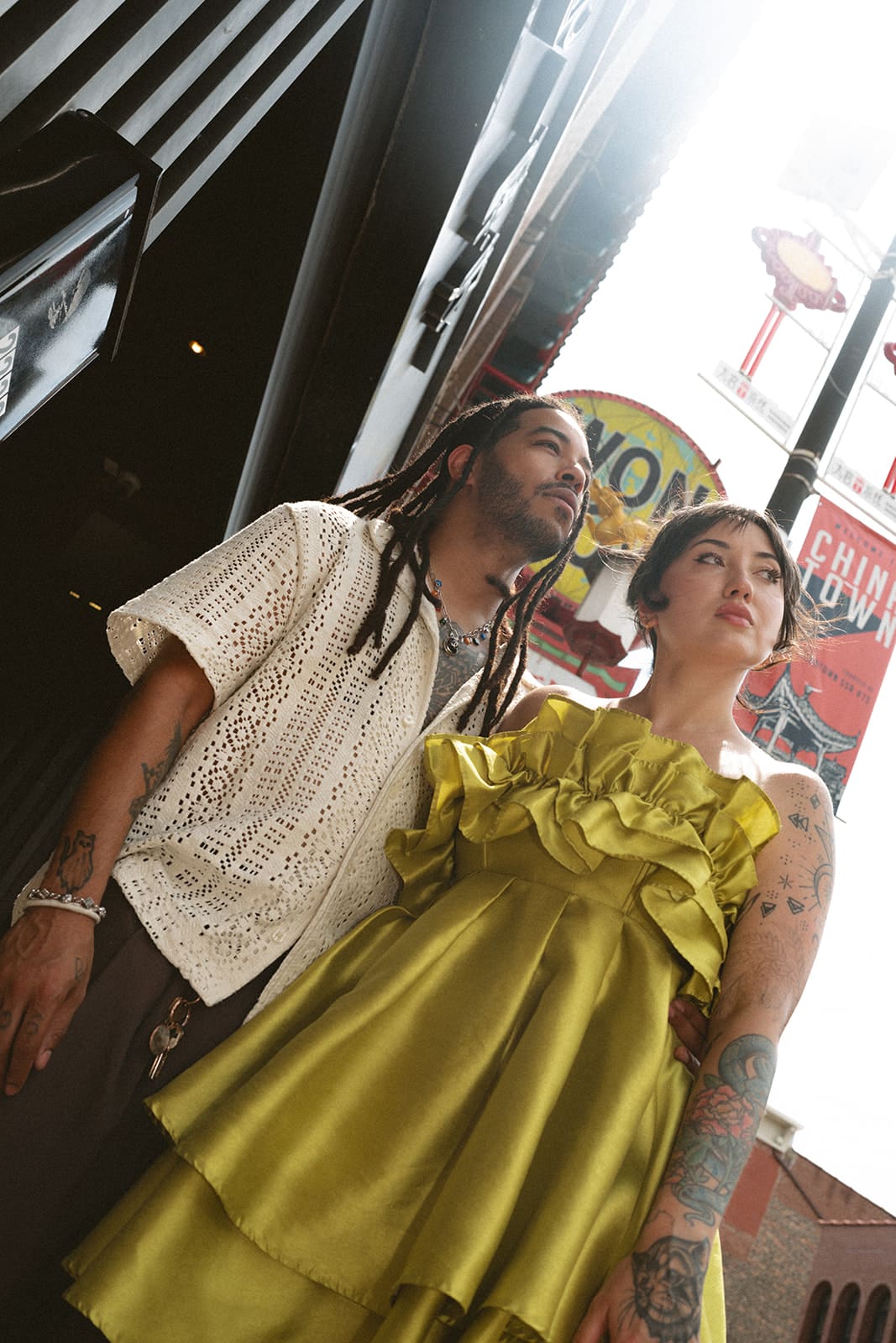 A couple taking summer engagement photos in chinatown