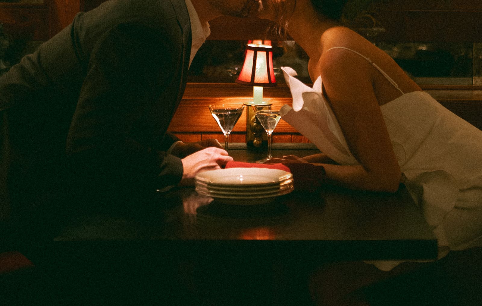 A couple leaned over a bar taking indoor engagement photos